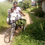 Sierra Leone farmer Aminata Sesay and child on her cargo trike