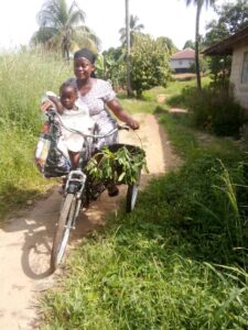 Sierra Leone farmer Aminata Sesay and child on her cargo trike